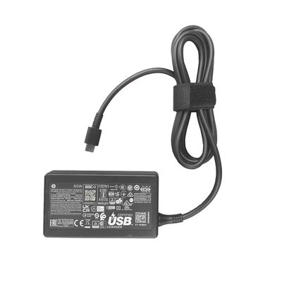 A black HP 65W USB-C laptop adapter with a coiled cable held by a Velcro strap and a USB-C connector
