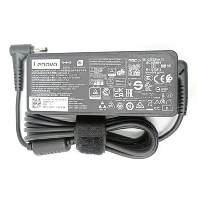A grey Lenovo 65W laptop adapter with a rating label and a coiled cable held by a Velcro strap