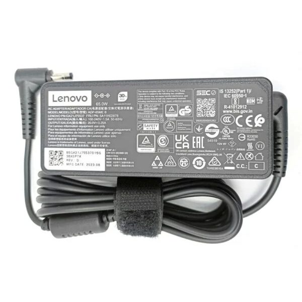 A grey Lenovo 65W laptop adapter with a rating label and a coiled cable held by a Velcro strap